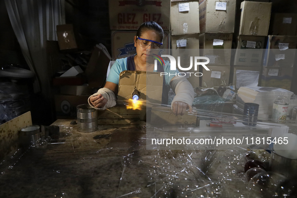 Josefina Aguilar, an industrial biochemist, makes handcrafted balls made of blown glass for sale in the Tlahuac municipality, Mexico City, o...