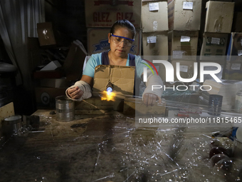 Josefina Aguilar, an industrial biochemist, makes handcrafted balls made of blown glass for sale in the Tlahuac municipality, Mexico City, o...