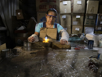 Josefina Aguilar, an industrial biochemist, makes handcrafted balls made of blown glass for sale in the Tlahuac municipality, Mexico City, o...