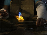 Josefina Aguilar, an industrial biochemist, makes handcrafted balls made of blown glass for sale in the Tlahuac municipality, Mexico City, o...