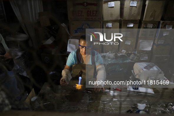 Josefina Aguilar, an industrial biochemist, makes handcrafted balls made of blown glass for sale in the Tlahuac municipality, Mexico City, o...