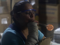 Josefina Aguilar, an industrial biochemist, makes handcrafted balls made of blown glass for sale in the Tlahuac municipality, Mexico City, o...