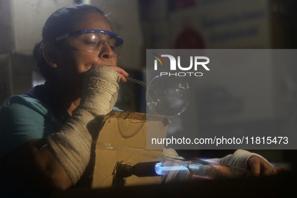 Josefina Aguilar, an industrial biochemist, makes handcrafted balls made of blown glass for sale in the Tlahuac municipality, Mexico City, o...