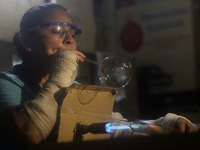 Josefina Aguilar, an industrial biochemist, makes handcrafted balls made of blown glass for sale in the Tlahuac municipality, Mexico City, o...