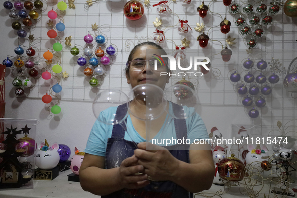 Josefina Aguilar, an industrial biochemist, holds handcrafted balls made of blown glass for sale in the Tlahuac municipality, Mexico City, o...