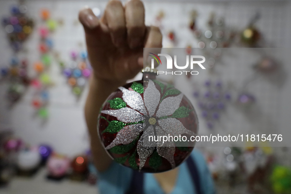 Josefina Aguilar, an industrial biochemist, holds handcrafted balls made of blown glass for sale in the Tlahuac municipality, Mexico City, o...