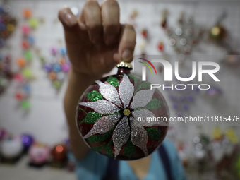 Josefina Aguilar, an industrial biochemist, holds handcrafted balls made of blown glass for sale in the Tlahuac municipality, Mexico City, o...