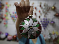 Josefina Aguilar, an industrial biochemist, holds handcrafted balls made of blown glass for sale in the Tlahuac municipality, Mexico City, o...