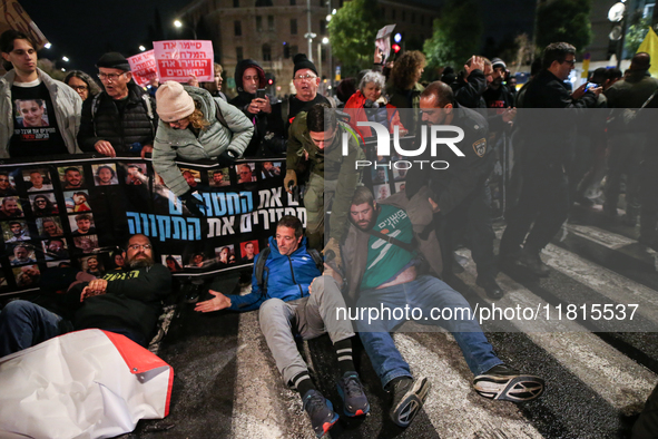 Police officers drag demonstrators as people block a road during a protest in support of the hostages kidnapped during the deadly October 7,...