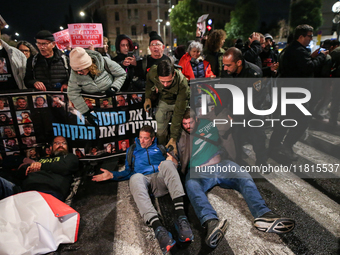 Police officers drag demonstrators as people block a road during a protest in support of the hostages kidnapped during the deadly October 7,...