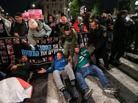 Police officers drag demonstrators as people block a road during a protest in support of the hostages kidnapped during the deadly October 7,...