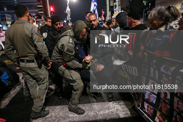 Police officers drag demonstrators as people block a road during a protest in support of the hostages kidnapped during the deadly October 7,...