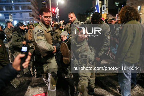 Police officers drag demonstrators as people block a road during a protest in support of the hostages kidnapped during the deadly October 7,...