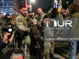 Police officers drag demonstrators as people block a road during a protest in support of the hostages kidnapped during the deadly October 7,...