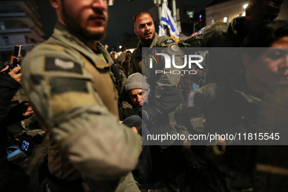 Police officers drag demonstrators as people block a road during a protest in support of the hostages kidnapped during the deadly October 7,...