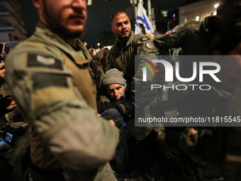 Police officers drag demonstrators as people block a road during a protest in support of the hostages kidnapped during the deadly October 7,...