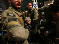 Police officers drag demonstrators as people block a road during a protest in support of the hostages kidnapped during the deadly October 7,...