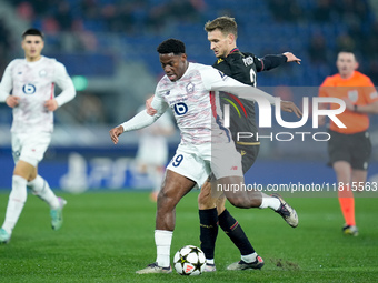 Jonathan David of LOSC Lille and Stefan Posch of Bologna FC during the UEFA Champions League 2024/25 League Phase MD5 match between Bologna...