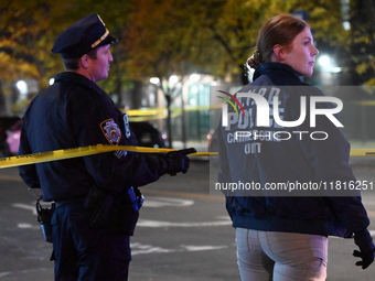 Crime scene investigators with the NYPD mark evidence at the scene and a vehicle with bullet holes where a 29-year-old man is shot in the ch...