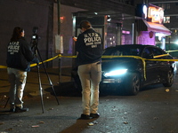 Crime scene investigators with the NYPD mark evidence at the scene and a vehicle with bullet holes where a 29-year-old man is shot in the ch...