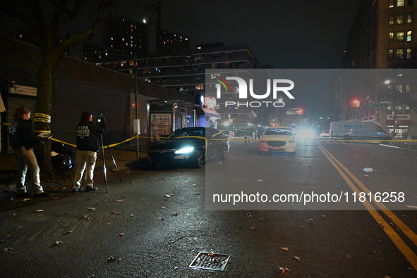 Crime scene investigators with the NYPD mark evidence at the scene and a vehicle with bullet holes where a 29-year-old man is shot in the ch...