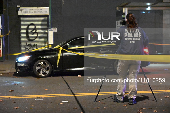 Crime scene investigators with the NYPD mark evidence at the scene and a vehicle with bullet holes where a 29-year-old man is shot in the ch...