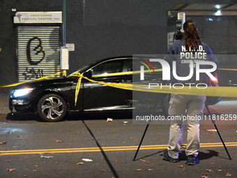 Crime scene investigators with the NYPD mark evidence at the scene and a vehicle with bullet holes where a 29-year-old man is shot in the ch...