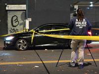 Crime scene investigators with the NYPD mark evidence at the scene and a vehicle with bullet holes where a 29-year-old man is shot in the ch...