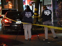 Crime scene investigators with the NYPD mark evidence at the scene and a vehicle with bullet holes where a 29-year-old man is shot in the ch...