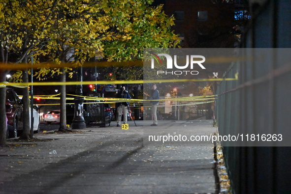 Crime scene investigators with the NYPD mark evidence at the scene and a vehicle with bullet holes where a 29-year-old man is shot in the ch...