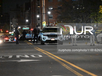 Crime scene investigators with the NYPD mark evidence at the scene and a vehicle with bullet holes where a 29-year-old man is shot in the ch...