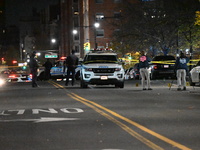 Crime scene investigators with the NYPD mark evidence at the scene and a vehicle with bullet holes where a 29-year-old man is shot in the ch...