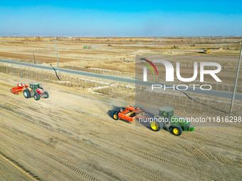 Large machinery levels the land at a high-standard farmland construction site in Weili County, Bayingoleng Mongolian Autonomous Prefecture,...