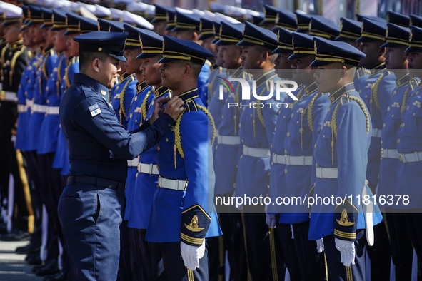 A military officer adjusts the uniform of a member of the royal guard during a welcoming ceremony for Singapore's Prime Minister Lawrence Wo...