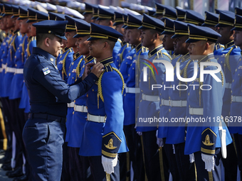 A military officer adjusts the uniform of a member of the royal guard during a welcoming ceremony for Singapore's Prime Minister Lawrence Wo...