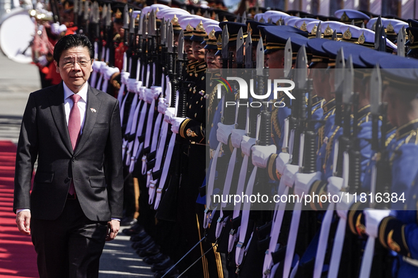 Singapore's Prime Minister Lawrence Wong reviews the guard of honor during a welcoming ceremony at Government House in Bangkok, Thailand, on...