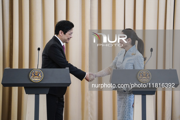 Singapore's Prime Minister Lawrence Wong shakes hands with Thailand's Prime Minister Paetongtarn Shinawatra during a press conference at Gov...