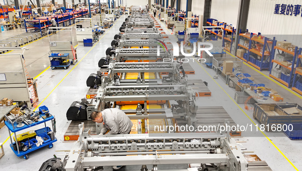 Workers assemble shuttleless looms at a workshop of Qingdao Century Haijia Machinery Co., LTD in Qingdao, China, on November 28, 2024. 