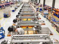 Workers assemble shuttleless looms at a workshop of Qingdao Century Haijia Machinery Co., LTD in Qingdao, China, on November 28, 2024. (