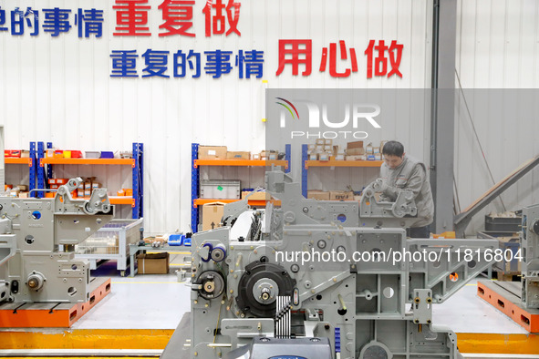 Workers assemble shuttleless looms at Qingdao Century Haijia Machinery Co., LTD in Qingdao, China, on November 28, 2024. 