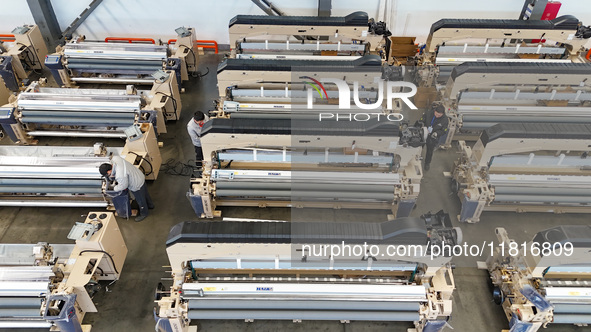 Workers make the final adjustment of a water-jet loom to be exported at the workshop of Qingdao Century Haijia Machinery Co., LTD in Qingdao...