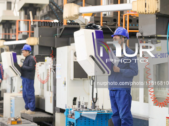 Workers produce slitting machine parts at Qingdao Kaisheng CNC Equipment Co., LTD., in Qingdao, China, on November 28, 2024. (