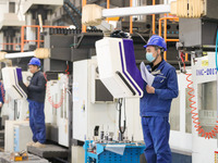 Workers produce slitting machine parts at Qingdao Kaisheng CNC Equipment Co., LTD., in Qingdao, China, on November 28, 2024. (