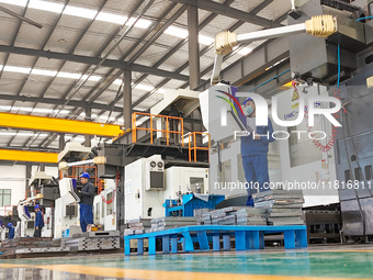 Workers produce slitting machine parts at Qingdao Kaisheng CNC Equipment Co., LTD., in Qingdao, China, on November 28, 2024. (