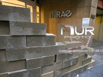 French farmers construct a symbolic wall in front of the French National Institute for Agricultural Research (INRAE) head office to represen...