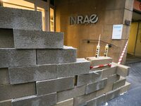 French farmers construct a symbolic wall in front of the French National Institute for Agricultural Research (INRAE) head office to represen...