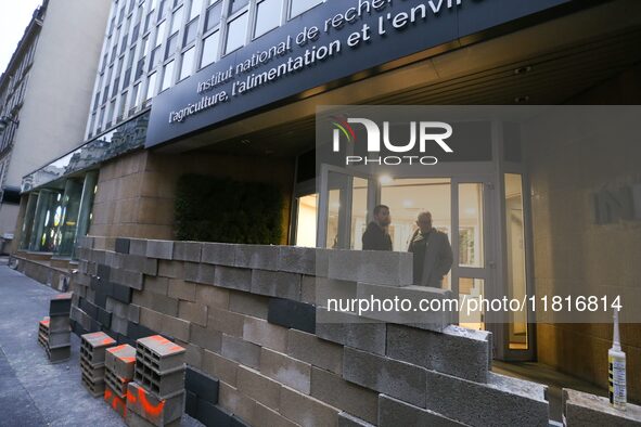 French farmers construct a symbolic wall in front of the French National Institute for Agricultural Research (INRAE) head office to represen...