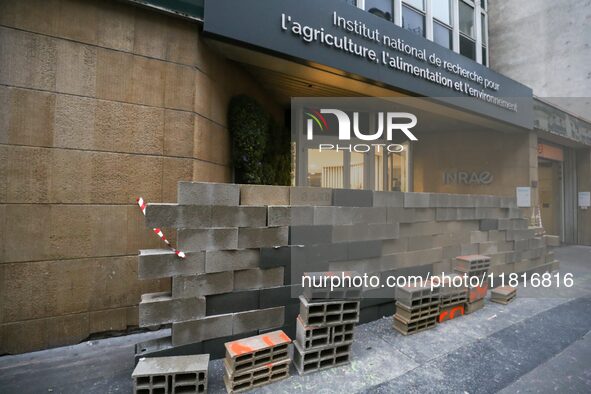 French farmers construct a symbolic wall in front of the French National Institute for Agricultural Research (INRAE) head office to represen...