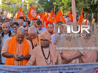 Activists of India's Hindu Jagaran Mancha, along with monks of ISKCON, hold placards showing a photo of Chinmoy Krishna Das Brahmachari, a B...