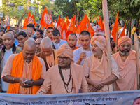 Activists of India's Hindu Jagaran Mancha, along with monks of ISKCON, hold placards showing a photo of Chinmoy Krishna Das Brahmachari, a B...